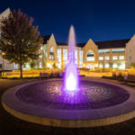 The Anderson Student Center and the fountain glowing purple on the John P. Monahan Plaza at dusk. Liam James Doyle/University of St. Thomas