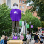 The statue of Archbishop John Ireland stands adorned with a purple shirt, mask and care packet that was available to all students on the St. Paul campus. Liam James Doyle/University of St. Thomas