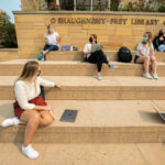 Students sit on the steps of the O'Shaughness-Frey Library during a communications class. Liam James Doyle/University of St. Thomas