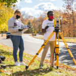 Students in Dr. Deborah Besser’s Civil Engineering class wear masks and gloves while working together in groups and using surveying equipment alongside Mississippi River Boulevard. Liam James Doyle/University of St. Thomas