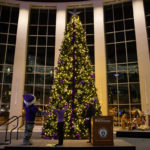 A holiday tree with decorations and lights stands in the Anderson Student Center.