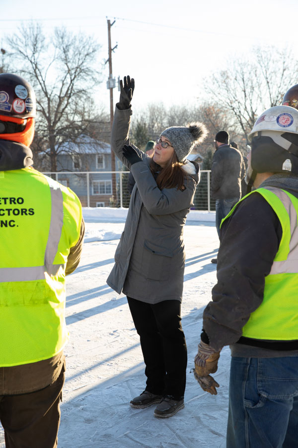 Art History Professor Victoria Young talks with a construction crew in preparation for the installation of a new sculpture of St. Thomas Aquinas by Canadian artist Timothy P. Schmalz. Mark Brown/University of St. Thomas