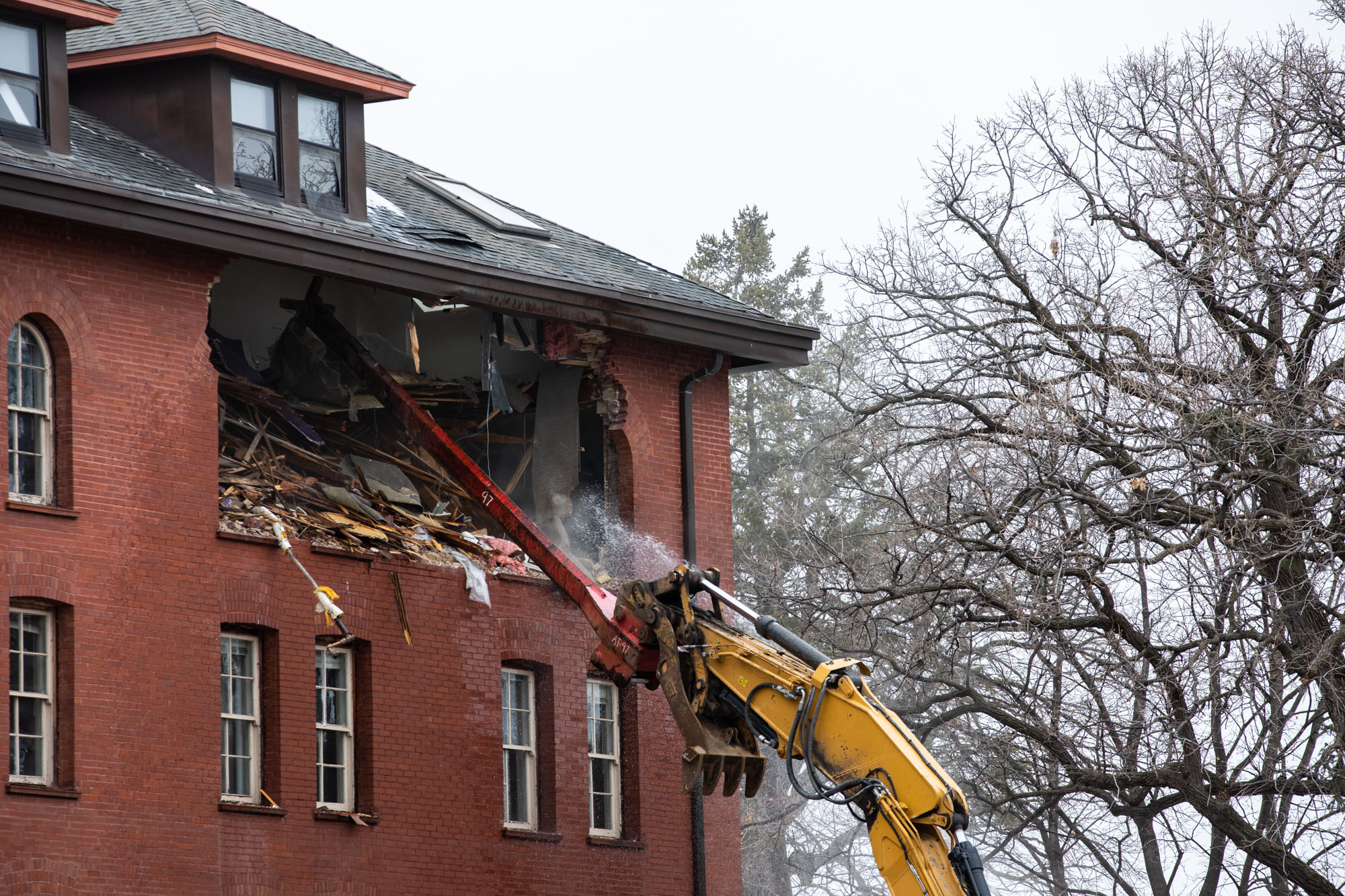An excavator starts to demolish Loras Hall.