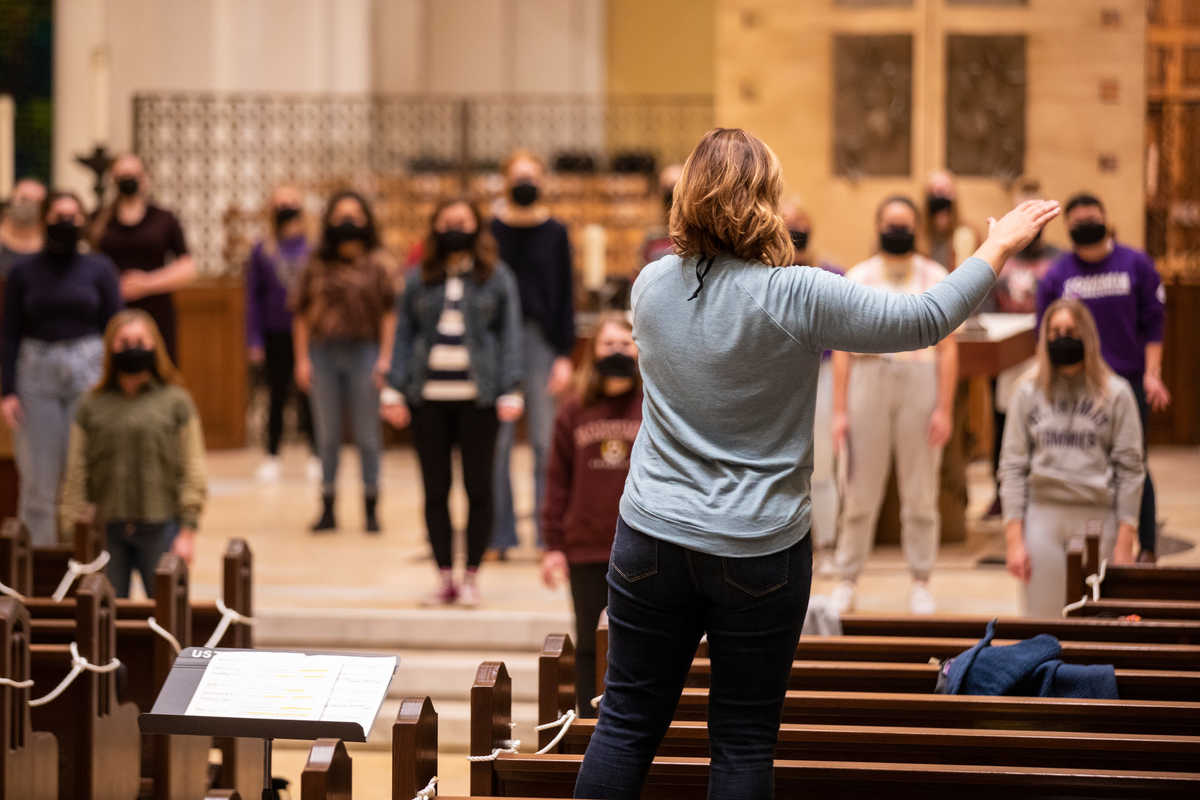 Masked and socially distanced, Angela Mitchell conducts the Donne Unite women’s chorus during a rehearsal inside of the Aquinas Chapel in St. Paul on November 17, 2020.