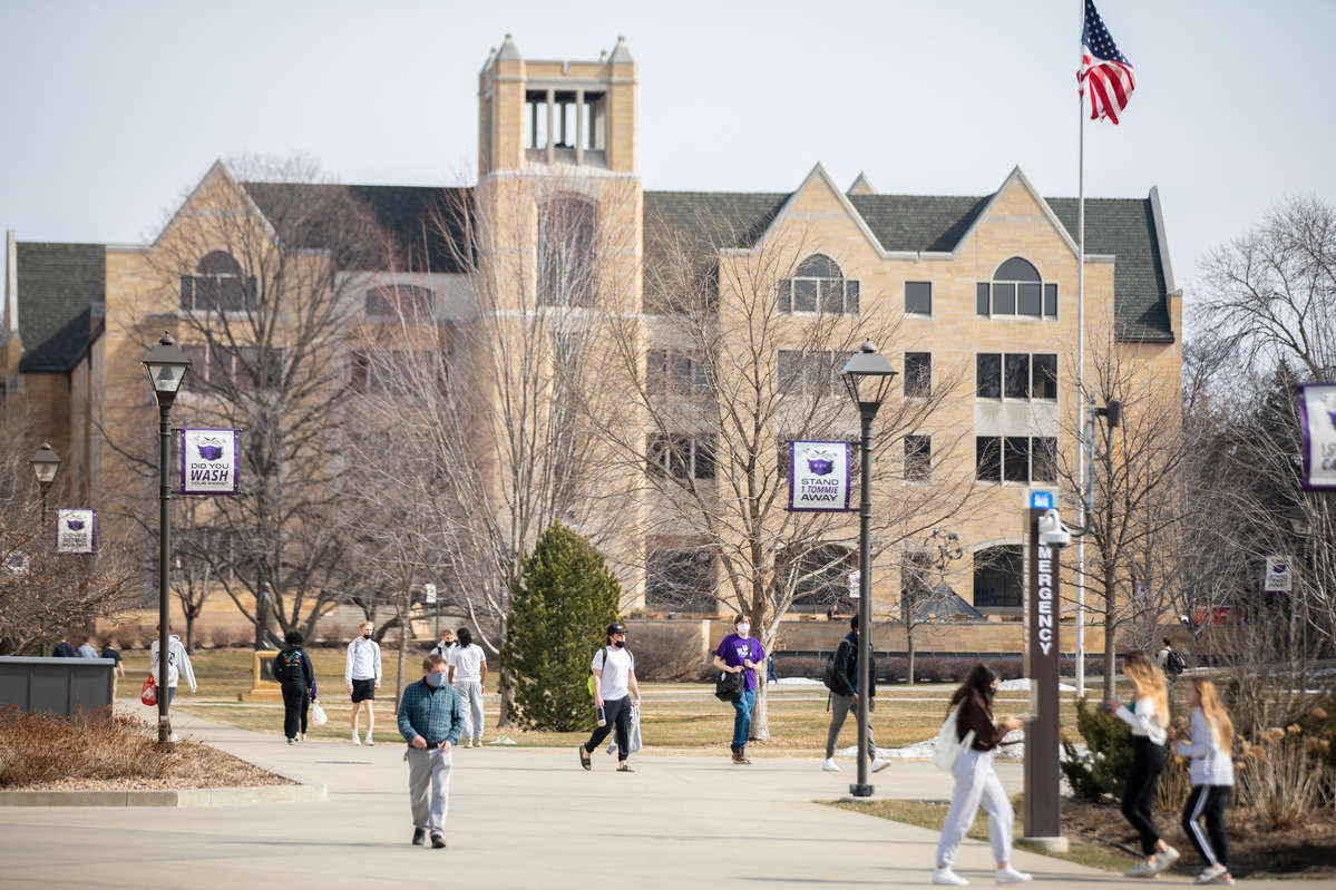 Students pass by the lower quad with the O'Shaughnessy-Frey Library Center in the background.