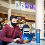 Noah Becker, freshman and member of Undergraduate Student Government (USG), participates in a virtual USG senate meeting in the Anderson Student Center. Liam James Doyle/University of St. Thomas
