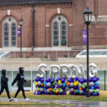Students walk through the upper quad past “Spring” spelled out in balloons. Mark Brown/University of St. Thomas
