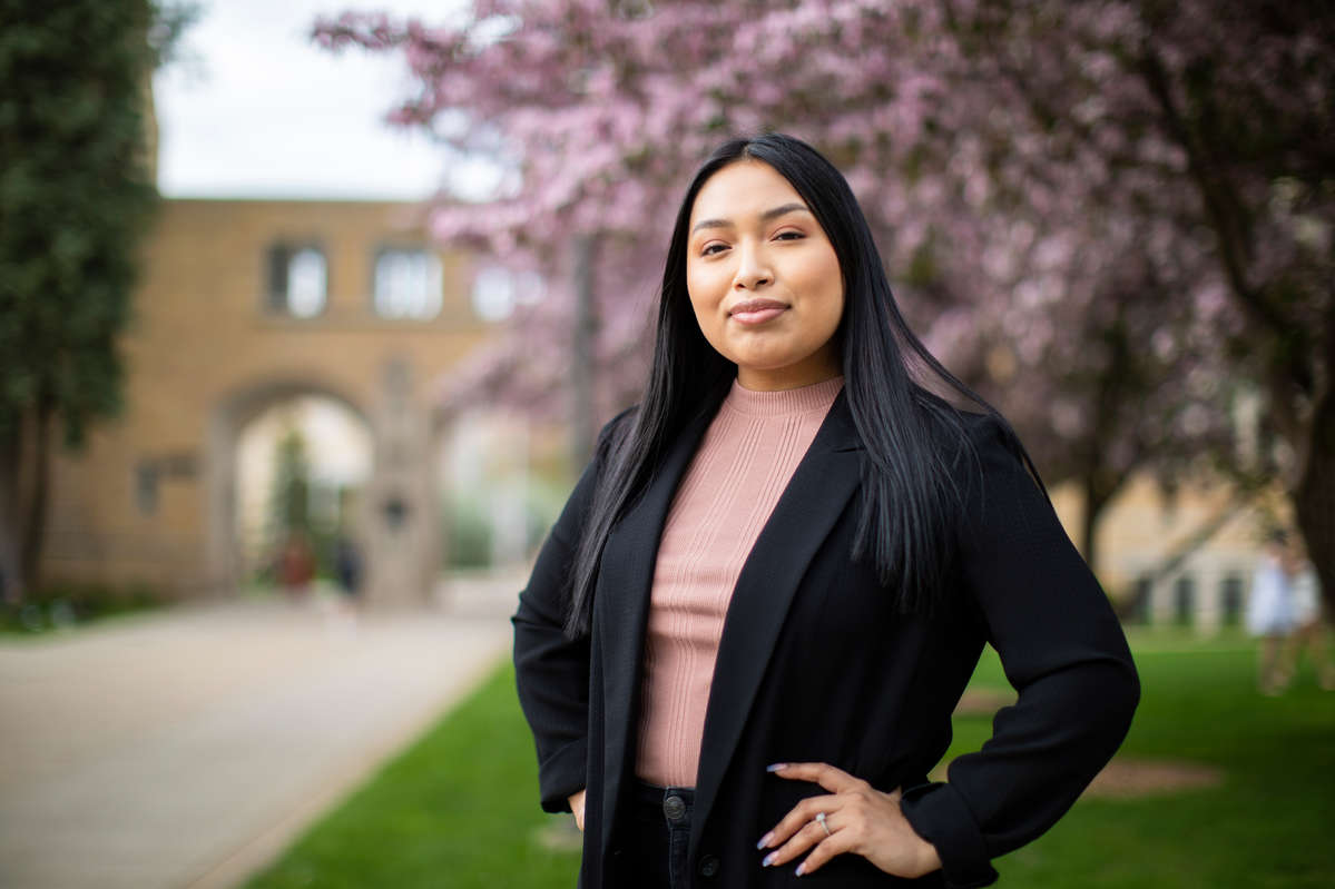 Senior Krystal Blas Rodriguez stands for a portrait amongst the blossoming trees in front of the Arches on the St. Paul campus on May 3, 2021. Krystal was photographed for an upcoming Newsroom and Magazine story featuring University of St. Thomas 2021 graduates who were previously a part of the Dougherty Family College’s inaugural class.