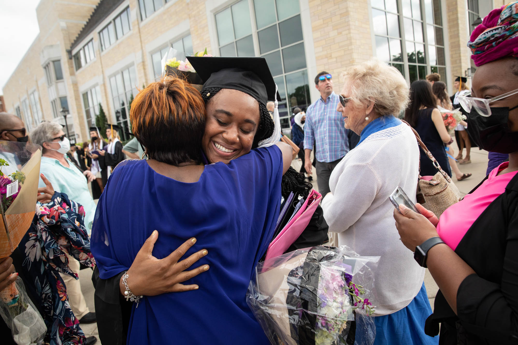 Deja Copeland, student speaker for the College of Arts and Sciences commencement, hugs a family member after the ceremony in St. Paul on May 22, 2021.