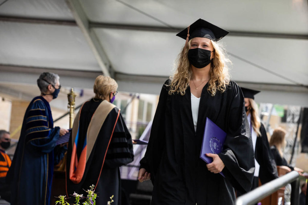 A student walks across the stage during the Opus College of Business undergraduate commencement ceremony. Mark Brown/University of St. Thomas