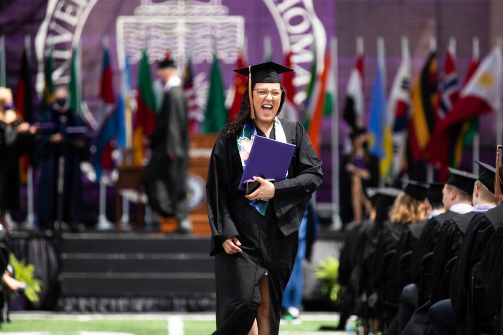 A student celebrates after getting a diploma during the Opus College of Business undergraduate commencement ceremony. Mark Brown/University of St. Thomas