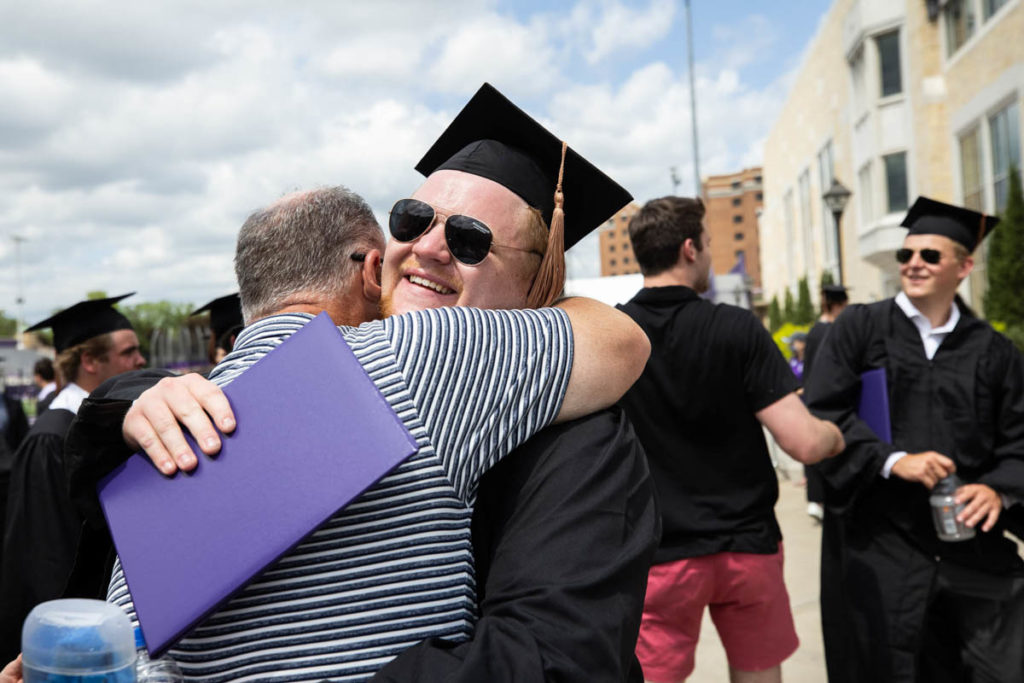A student hugs a family member after the Opus College of Business undergraduate commencement ceremony. Mark Brown/University of St. Thomas