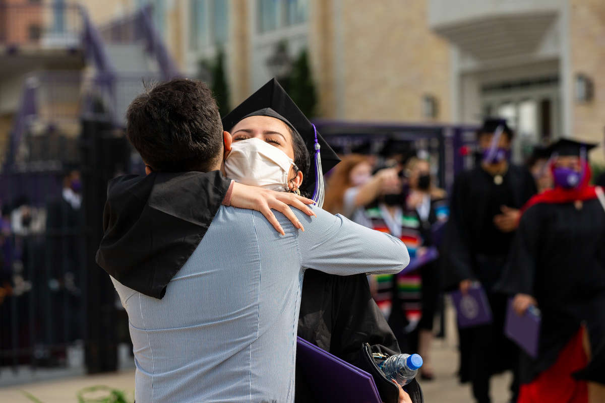 A student embraces their family following the Dougherty Family College commencement ceremony. Liam James Doyle/University of St. Thomas