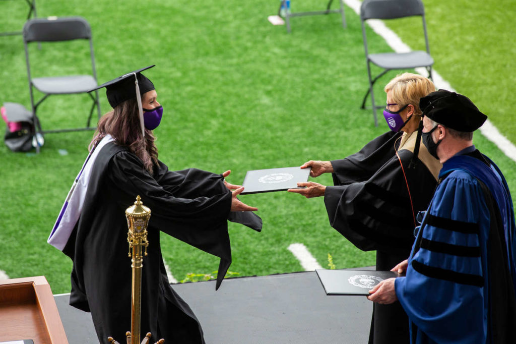 Students receive their diplomas during the graduate commencement ceremony. Liam James Doyle/University of St. Thomas