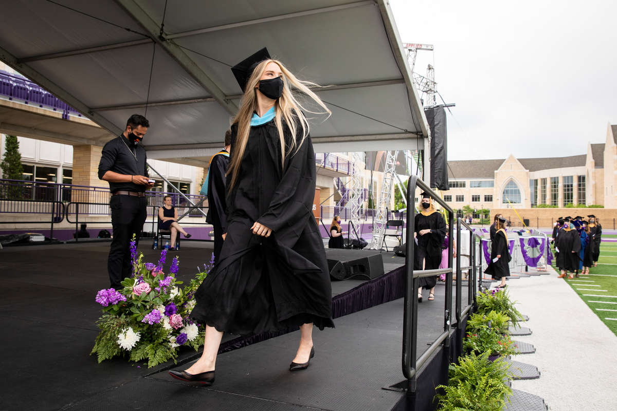 Students receive their diplomas during the graduate commencement ceremony for the College of Arts and Sciences, School of Education, Morrison Family College of Health, and the School of Divinity in O’Shaughnessy Stadium in St. Paul on May 23, 2021.