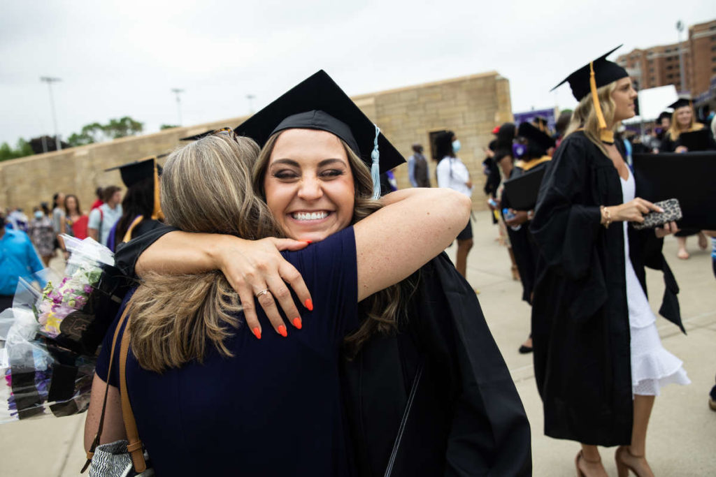 A student receives a hug after the commencement ceremony for graduate programs. Mark Brown/University of St. Thomas