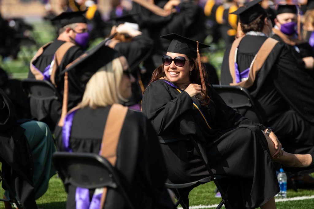 A student smiles during the commencement ceremony for graduate programs in the Opus College of Business and School of Engineering. Mark Brown/University of St. Thomas