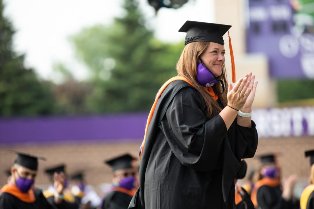A student applauds a speech during the commencement ceremony for graduate programs in the Opus College of Business and School of Engineering. Mark Brown/University of St. Thomas