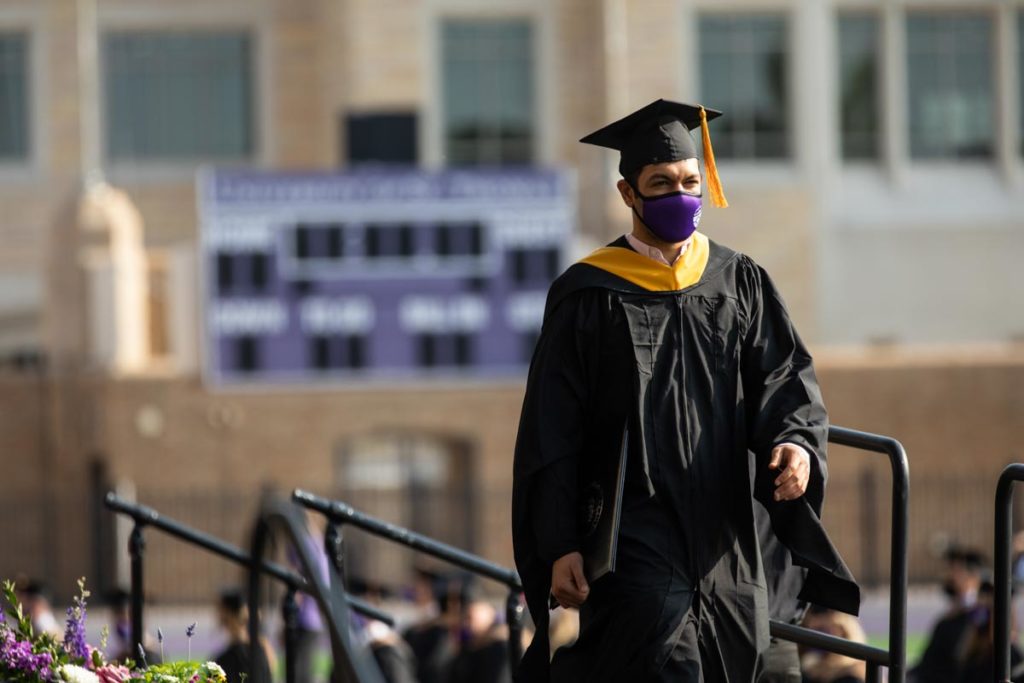 A student walks across the stage during the commencement ceremony for graduate programs in the Opus College of Business and School of Engineering. Mark Brown/University of St. Thomas