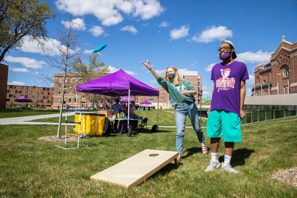 Students play bean-bag toss on the upper quad during a sunny spring afternoon. Liam James Doyle/University of St. Thomas