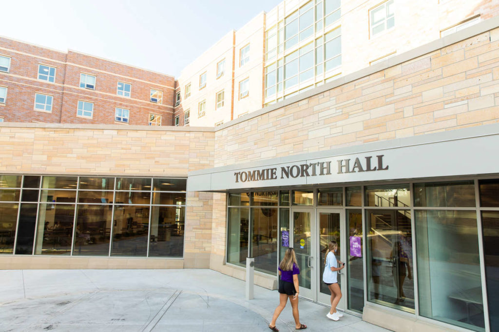 Students pass by Tommie North Residence Hall during a sunny evening. Liam James Doyle/University of St. Thomas