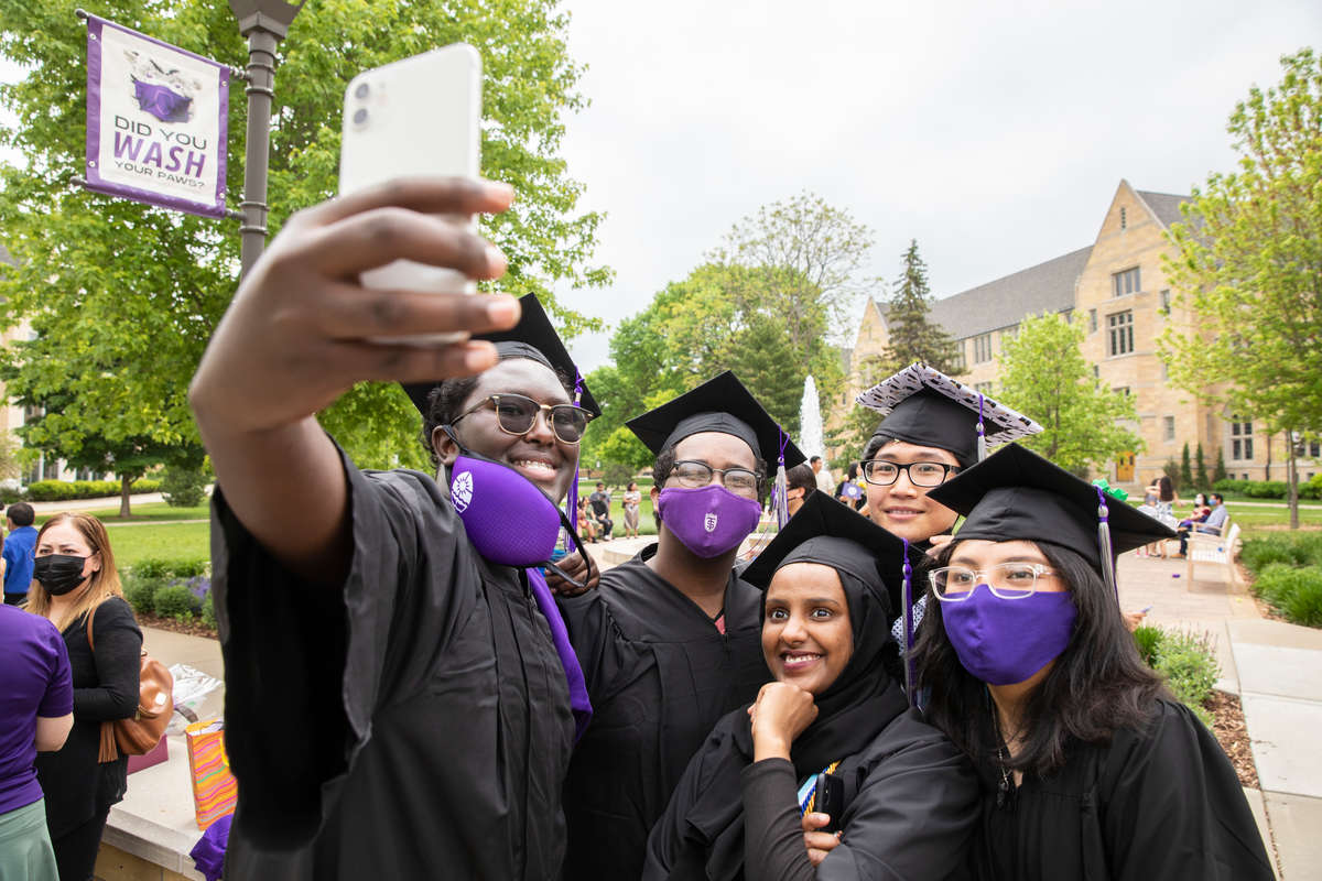 Students pose for a group photo and celebrate their graduation following the Dougherty Family College commencement ceremony.