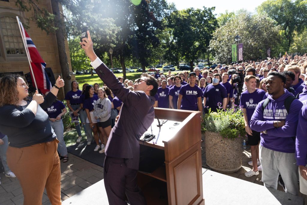 Undergraduate Student Government President Adam Revoir takes a selfie with fellow students during the annual “March Through the Arches” ceremony.