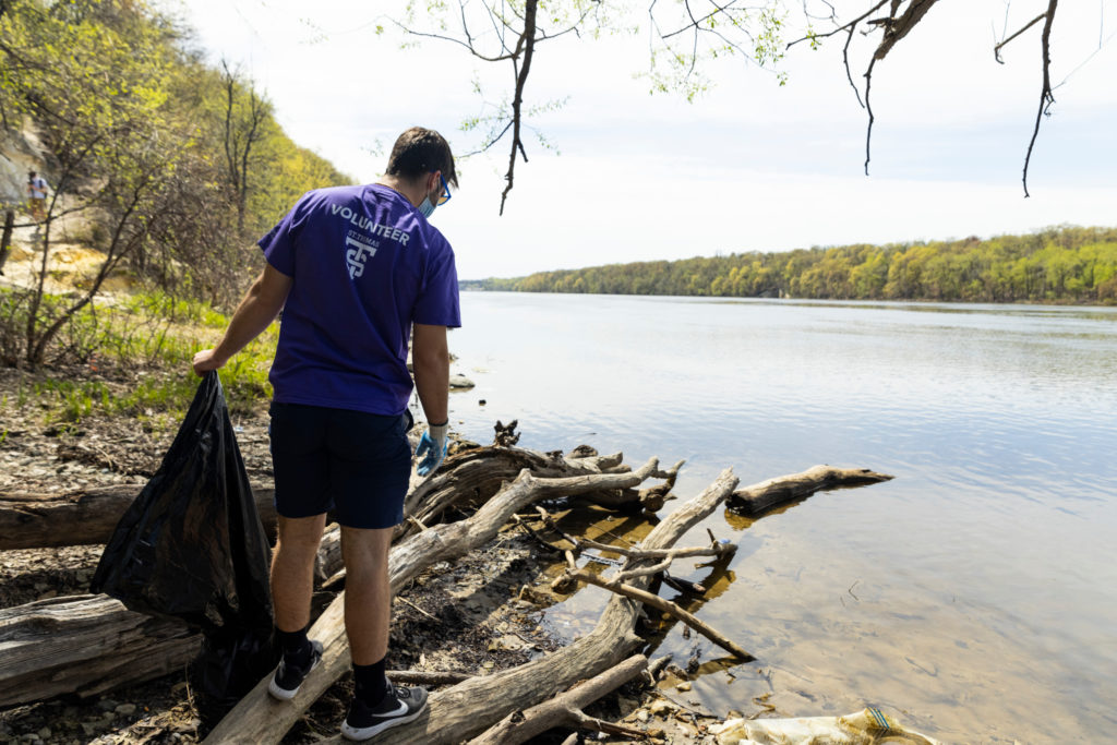 Student volunteers clean up garbage from the Mississippi River banks during The Big Event volunteer day facilitated by the Center for the Common Good on May 1, 2021, in St. Paul.