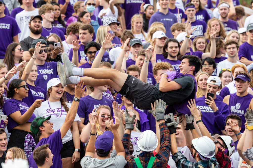 Caruso's Crew tosses a student in the air during the Homecoming Football game against Valparaiso University in St. Paul on October 9, 2021.