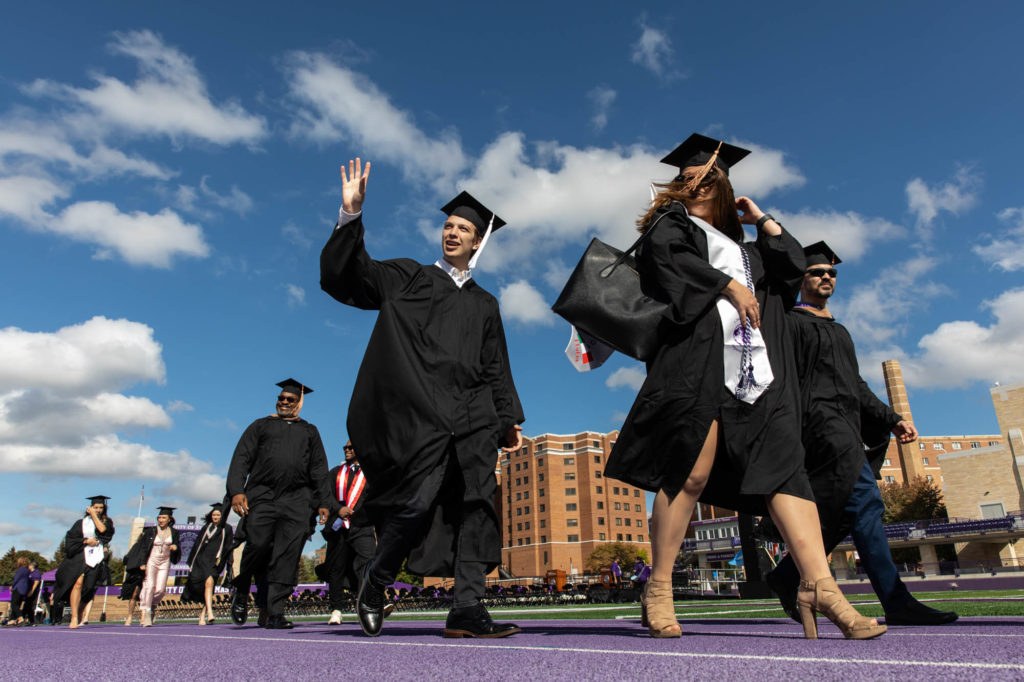 Graduates walk out of Palmer Field during a commencement.