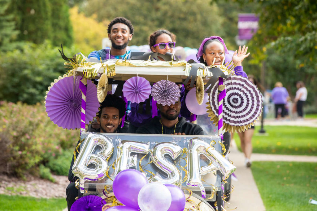 Student members of the Black Empowerment Student Alliance (BESA) ride their Golf Cart during the Homecoming Parade. Liam James Doyle/University of St. Thomas