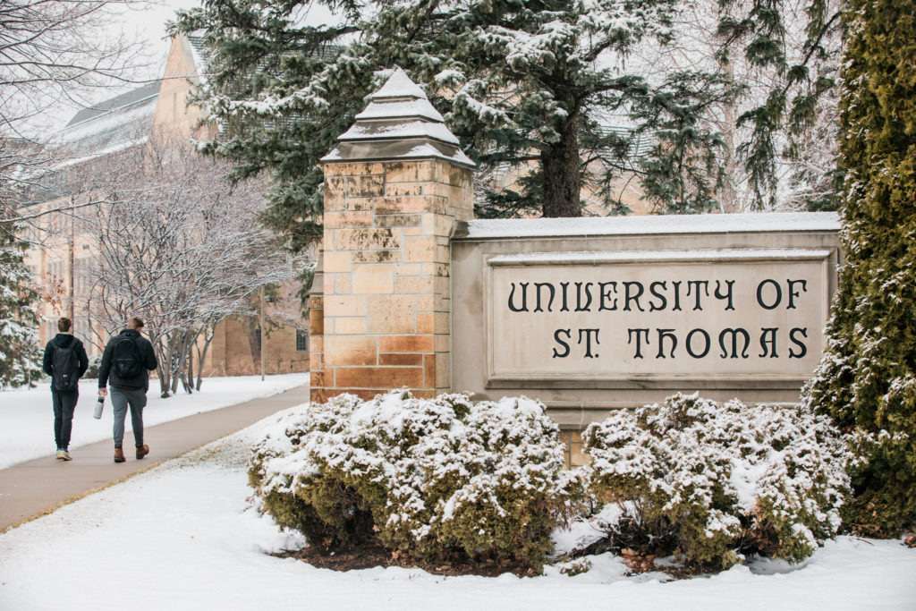 The University of St. Thomas monument sign at the corner of Summit and Cleveland after a late winter snowfall on the St. Paul campus on March 17, 2021.