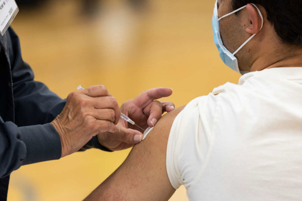 A student gets a vaccine shot during a vaccination clinic on the St. Paul campus in McCarthy Gym. Mark Brown/University of St. Thomas
