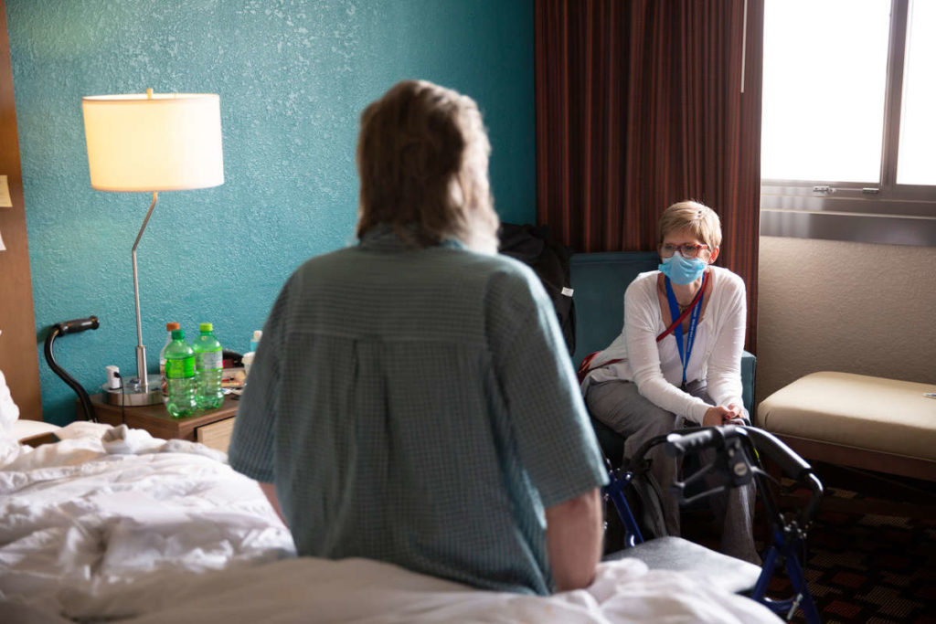 School of Social work alum Lori Halbur works with a client at the Best Western Capital Ridge in St. Paul. Halbur works at Catholic Charities. The focus of her job is finding temporary and permanent housing for older unhoused people. During the pandemic they have been working in partnership with Ramsey County to house seniors in hotels with open space. Mark Brown/University of St. Thomas