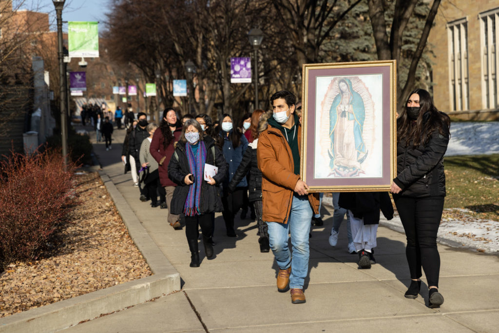 Students cary a portrait Our Lady of Guadalupe across campus on December 9, 2021, in St. Paul.