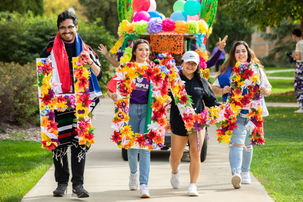 Student members of the Hispanic Organization for Leadership and Achievement (HOLA) march during the Homecoming Parade. Liam James Doyle/University of St. Thomas