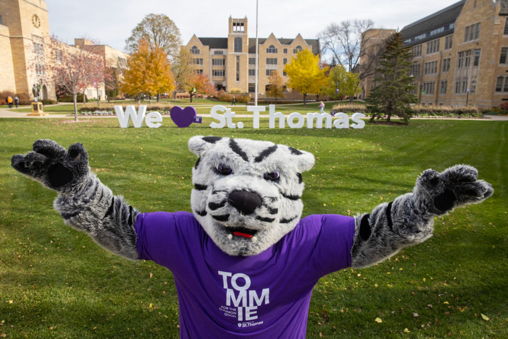 Tommie poses in front of the "We Love St. Thomas" sign on the lower quad. Liam James Doyle/University of St. Thomas
