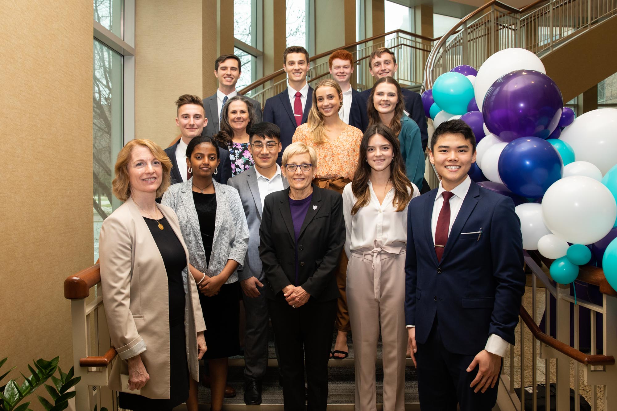 Pitch teams pose for a group photo with Laura Dunham and President Julie Sullivan during the Fowler Global Social Innovation Challenge in Schulze Hall on April 22, 2022, in Minneapolis.