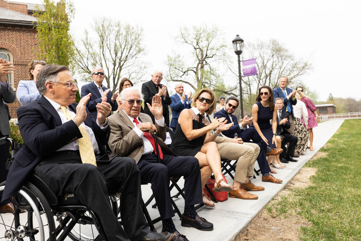 Attendees applaud for Gene Frey and his family during an event celebrating the Frey Room and Board Grants gift in front of the newly renamed Mary and Gene Frey Hall (formerly Tommie East) on May 11, 2022 in St. Paul.