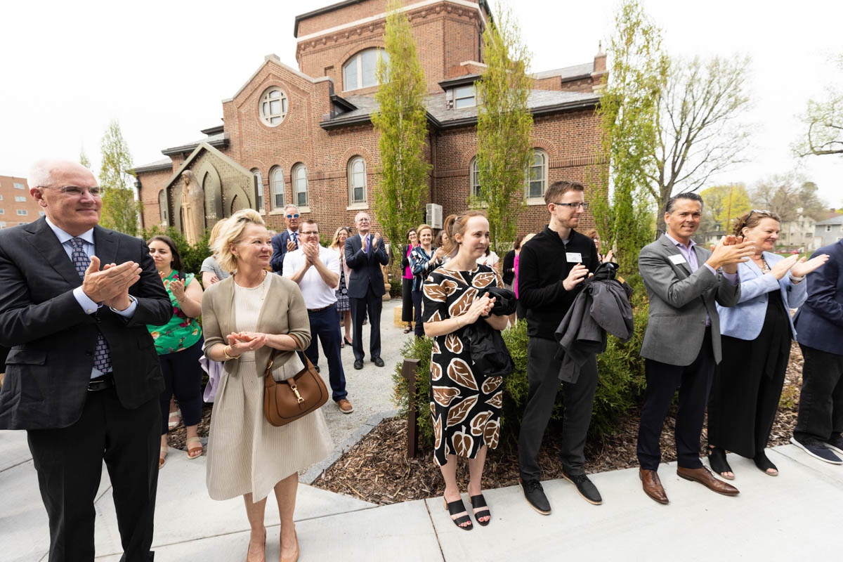 Attendees applaud for Gene Frey and his family during an event celebrating the Frey Room and Board Grants gift in front of the newly renamed Mary and Gene Frey Hall (formerly Tommie East) on May 11, 2022 in St. Paul.