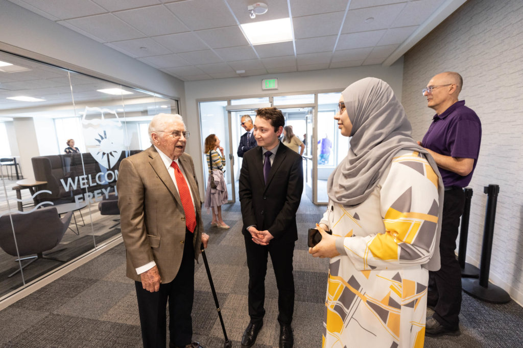 Gene Frey speaks with students Adam Revoir and Aiesha Roman during an event celebrating the Frey Room and Board Grants gift in the newly renamed Mary and Gene Frey Hall (formerly Tommie East) on May 11, 2022 in St. Paul.