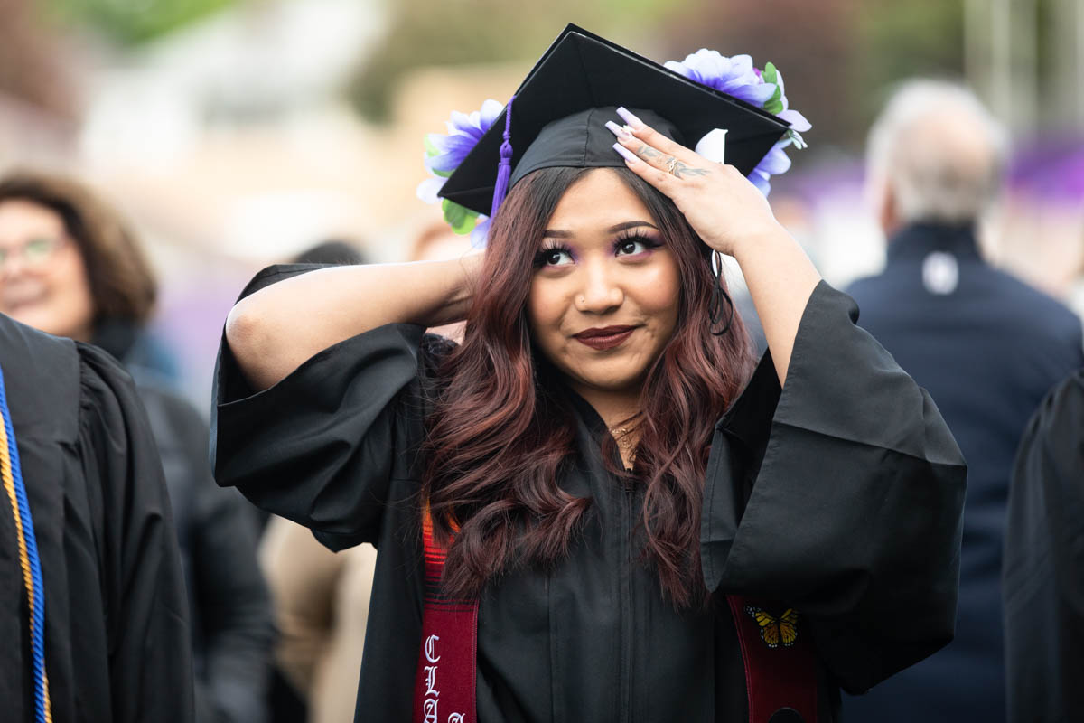 A student adjusts her cap during the 2022 Undergraduate Commencement Ceremony for the Dougherty Family College on May 22, 2022, in St. Paul.