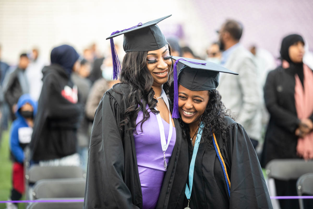 Students embrace during the 2022 Undergraduate Commencement Ceremony for the Dougherty Family College on May 22, 2022, in St. Paul.