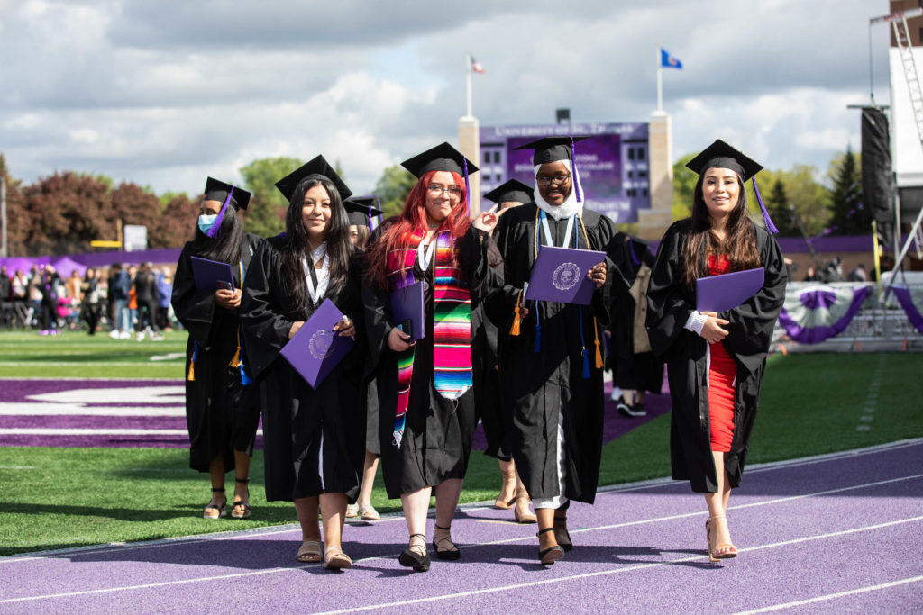 Students walk off the field after the 2022 Undergraduate Commencement Ceremony for the Dougherty Family College on May 22, 2022, in St. Paul.