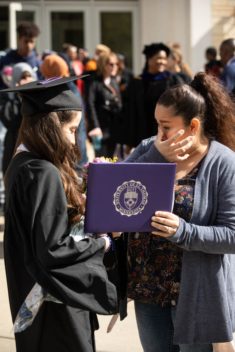 A family member cries with a graduate after the 2022 Undergraduate Commencement Ceremony for the Dougherty Family College on May 22, 2022, in St. Paul.