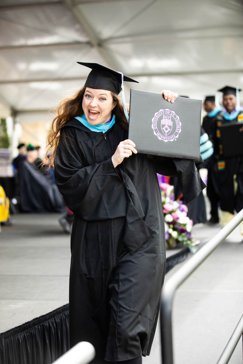 A student celebrates during the 2022 Graduate Commencement ceremony for the Opus College of Business, the School of Education and the School of Divinity in St. Paul on May 22, 2022.