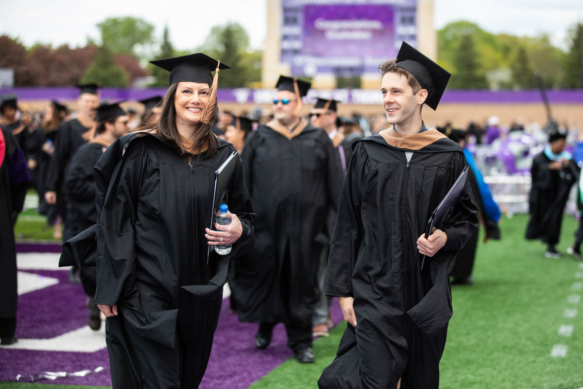 Graduates leave the stadium after the 2022 Graduate Commencement ceremony for the Opus College of Business, the School of Education and the School of Divinity in St. Paul on May 22, 2022.