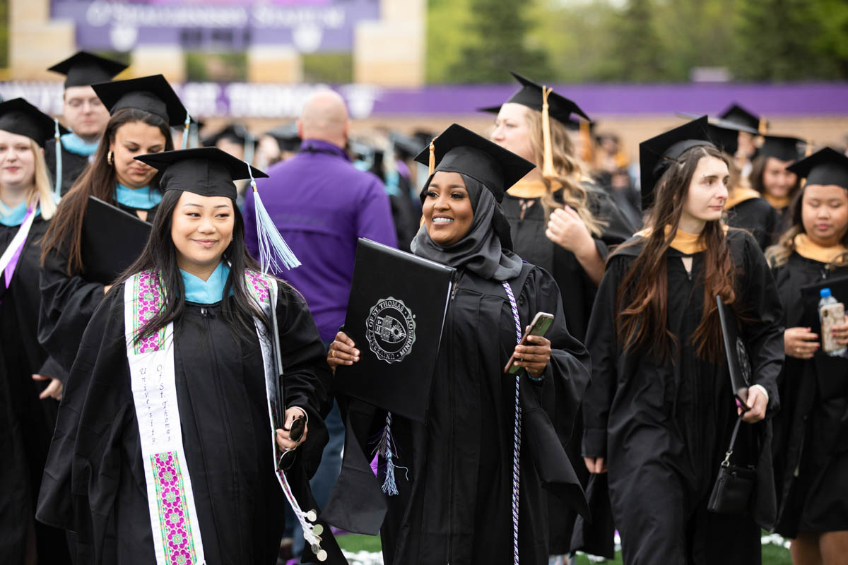 Students walk out of the stadium during the 2022 Graduate Commencement ceremony for the College of Arts and Sciences, the Morrison Family College of Health and the School of Engineering in St. Paul on May 22, 2022.