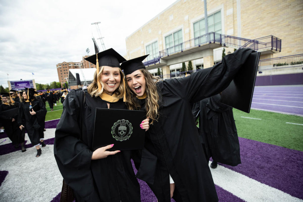 Students celebrate after the 2022 Graduate Commencement ceremony for the College of Arts and Sciences, the Morrison Family College of Health and the School of Engineering in St. Paul on May 22, 2022.