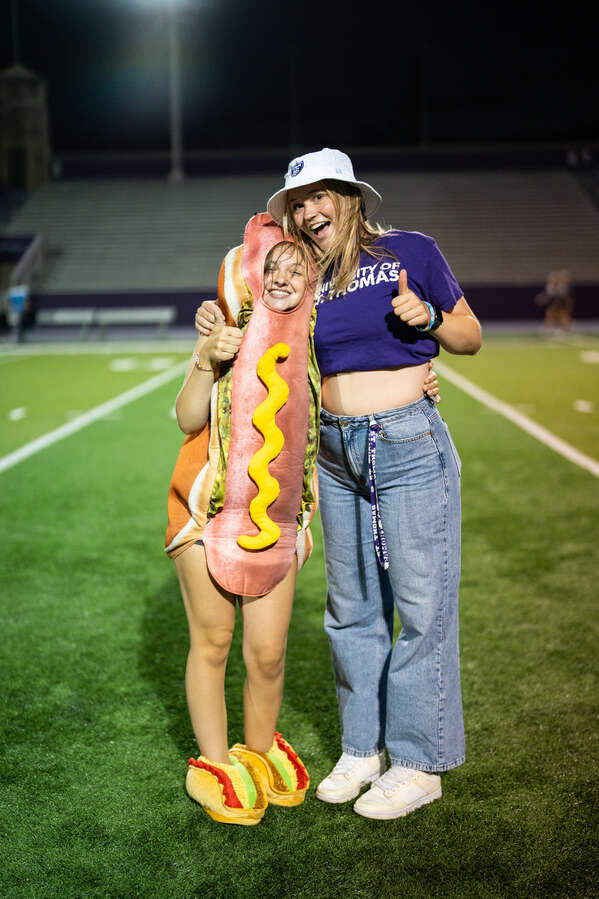 A student dressed in a hot dog costume poses for a photo with a friend during the 2023 Pep Rally. Mark Brown/University of St. Thomas